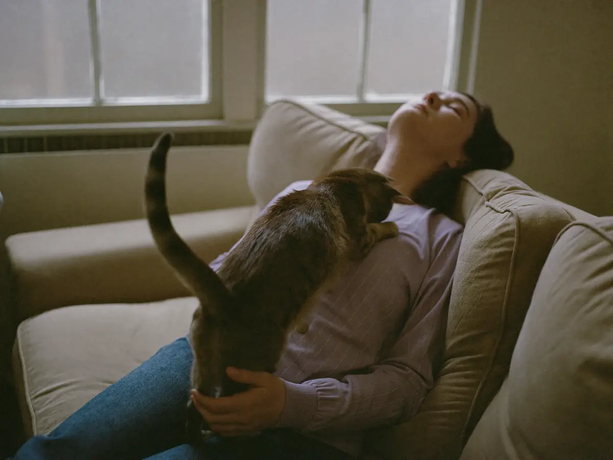 An owner subtly leaning back as her cat leans in close
